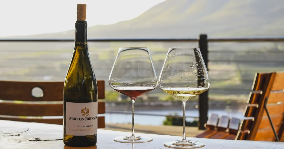 A bottle of Newton Johnson Albariño with two glasses overlooking the valley